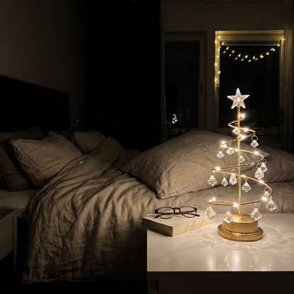 Tindra tänd på nattduksbordet i ett mörkt sovrum bredvid en bok och ett par läsglasögon