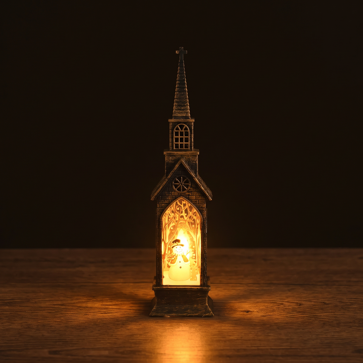 Vesper, sladdlös kyrklykta med snögubbemotiv, tänd på ett mörkt ekbord