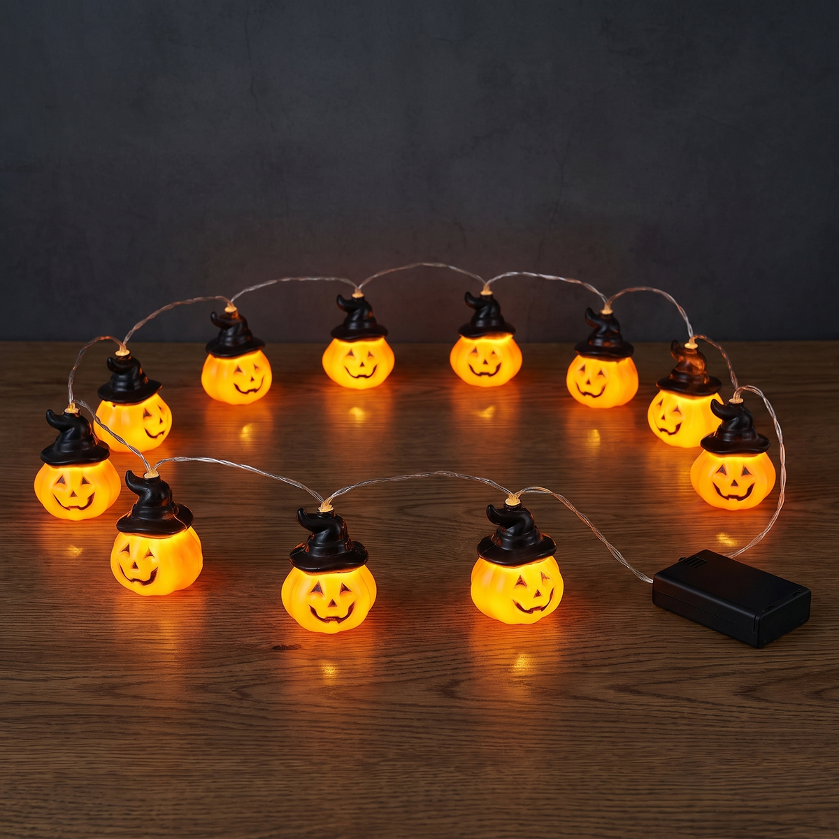 Umbra, batteridriven halloweenslinga med tio pumpor, på ett mörkt ekbord