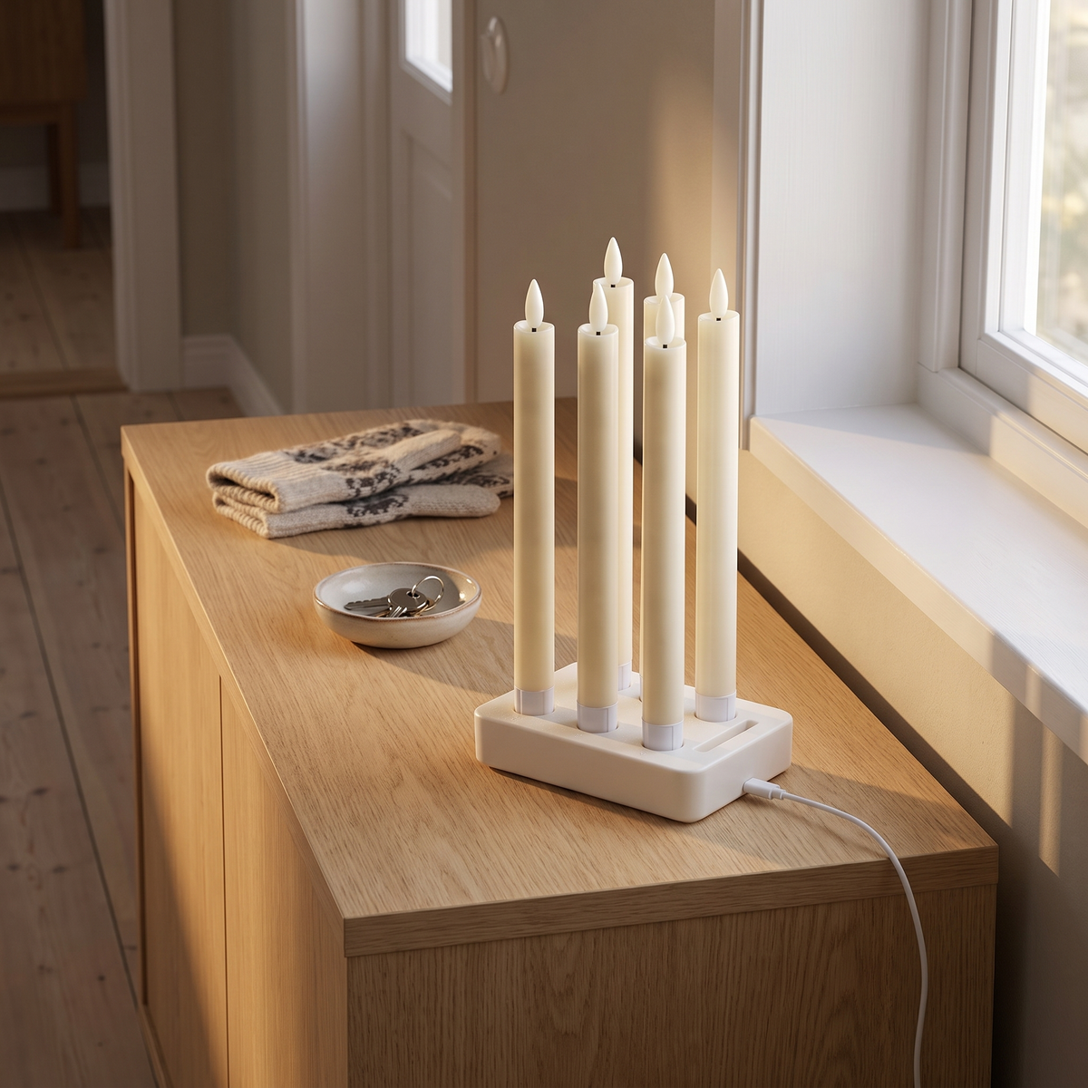 Velas laddstation med alla sex kronljus på en byrå i hallen, USB-C-kabeln inkopplad